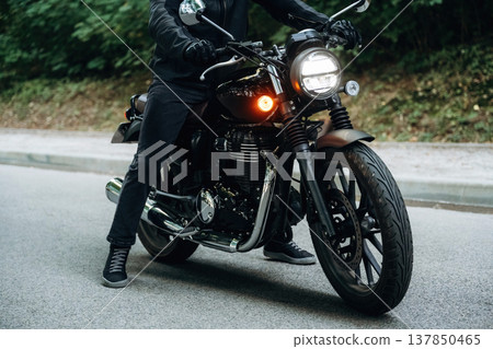 On the asphalt road. Close up detailed view of man with motorcycle On the asphalt road. Close up detailed view of man with motorcycle 137850465