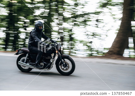 Driving fast. Man in leather clothes on motorcycle is on the road Driving fast. Man in leather clothes on motorcycle is on the road 137850467