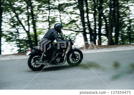 Speed conception, driving. Man in leather clothes on motorcycle is on the road Speed conception, driving. Man in leather clothes on motorcycle is on the road 137850475