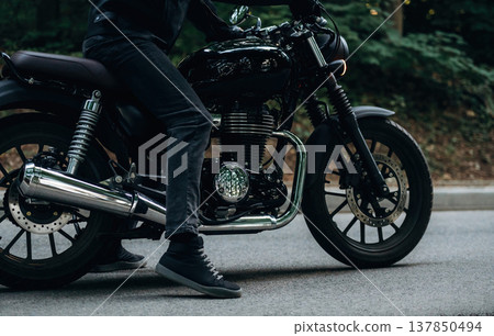 On the asphalt road. Close up detailed view of man with motorcycle On the asphalt road. Close up detailed view of man with motorcycle 137850494