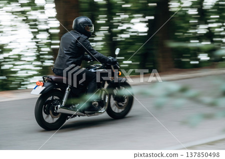 Speed conception, driving. Man in leather clothes on motorcycle is on the road Speed conception, driving. Man in leather clothes on motorcycle is on the road 137850498