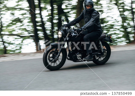 Speed conception, driving. Man in leather clothes on motorcycle is on the road Speed conception, driving. Man in leather clothes on motorcycle is on the road 137850499