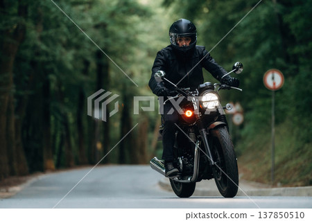 Protective helmet on head, safety first. Man in leather clothes on motorcycle is on the road 137850510