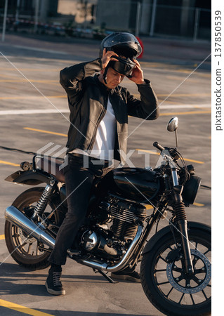 Wearing the safety helmet. Man is outdoors with his motorcycle 137850539