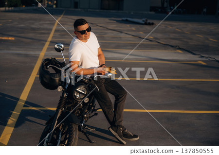 Yellow gloves is in hands. Man is outdoors with his motorcycle Yellow gloves is in hands. Man is outdoors with his motorcycle 137850555