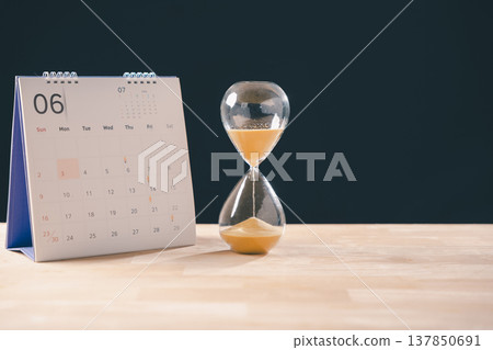 Hourglass depicts time running out, golden sand grains dropping steadily, calendar prominently highlights June 30 as crucial job hunting deadline, conveying urgency for application submission Hourglass depicts time running out, golden sand grains dropping steadily, calendar prominently highlights June 30 as crucial job hunting deadline, conveying urgency for application submission 137850691