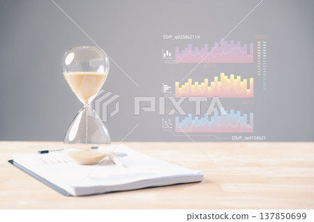 Hourglass symbolizes time passing on work papers, documents, business time management, illustrating urgency for important projects with analytical data charts 137850699