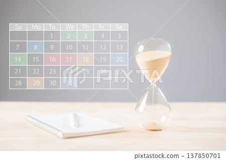 Hourglass time management concept illustrates sandglass countdown, showing business planning and scheduling deadlines, calendar dates with colorful highlights, open notebook, and pen Hourglass time management concept illustrates sandglass countdown, showing business planning and scheduling deadlines, calendar dates with colorful highlights, open notebook, and pen 137850701