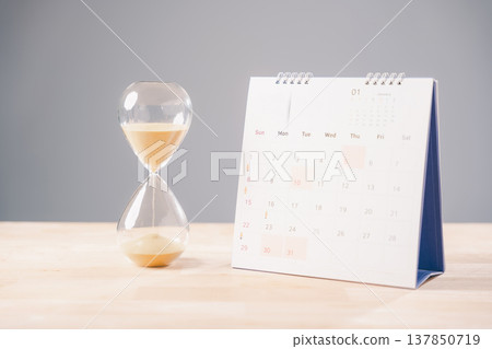 Glass hourglass shows time, calendar marks job deadline countdown, important schedule planning, work sand passes, hourglass symbolizes waiting for career changes 137850719