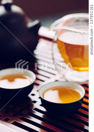 Teapot and cups with Chinese tea on the table Teapot and cups with Chinese tea on the table 137851161