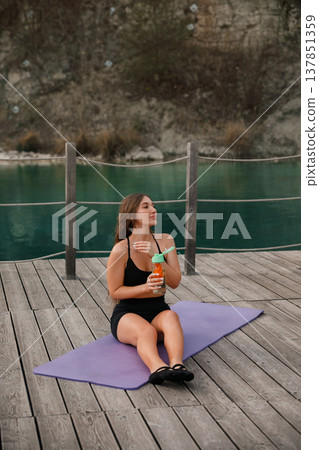 Beautiful Woman Drinking Water After Outdoor Workout At Lake. Hydration And Wellness Concept Beautiful Woman Drinking Water After Outdoor Workout At Lake. Hydration And Wellness Concept 137851359