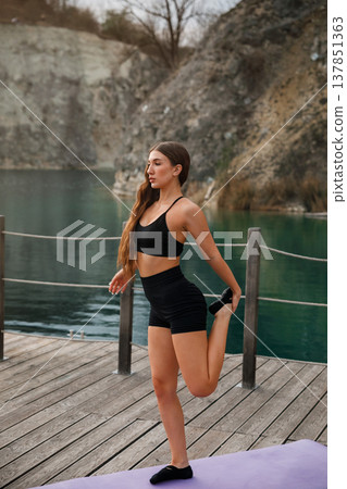 Beautiful Woman Practicing Yoga Outdoors At Lake. Fitness And Wellness Lifestyle Concept Beautiful Woman Practicing Yoga Outdoors At Lake. Fitness And Wellness Lifestyle Concept 137851363