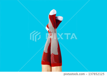 a man lifts his legs wearing red compression socks a man lifts his legs wearing red compression socks 137852125