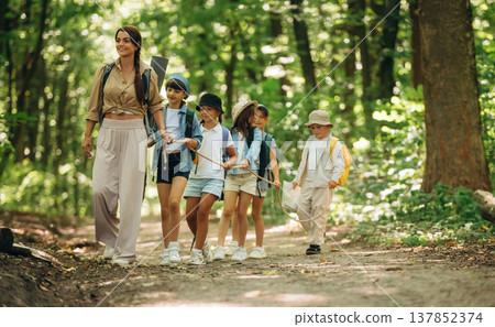 Knot in hands, for support. Woman is doing tour for group of kids in the forest Knot in hands, for support. Woman is doing tour for group of kids in the forest 137852374