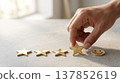 Hand placing a golden star to complete a five-star rating with a smiley face 137852619