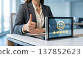 Businesswoman giving thumbs up with positive customer feedback displayed on a tablet screen 137852623
