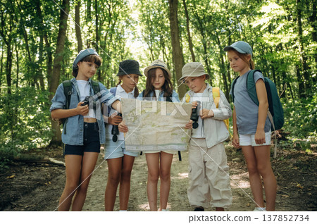 Searching for a right route. Group of children in the forest on a hike 137852734