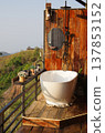 Outdoor bathroom with a stunning view featuring a white bathtub and shower fixture 137853152