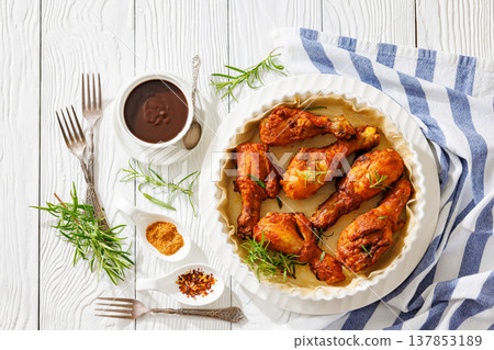 Roasted chicken drumsticks on paper in baking dish 137853189