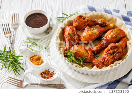 Roasted chicken drumsticks on paper in baking dish Roasted chicken drumsticks on paper in baking dish 137853190