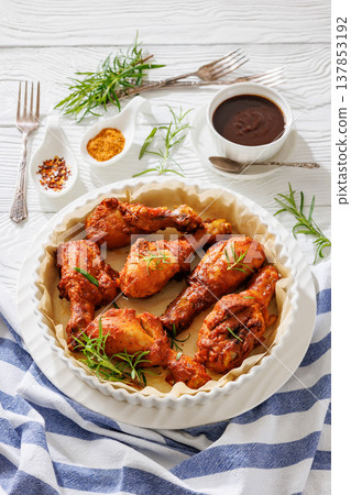 Roasted chicken drumsticks on paper in baking dish Roasted chicken drumsticks on paper in baking dish 137853192