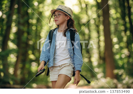 Exploring the nature. Young girl hiker is in the forest Exploring the nature. Young girl hiker is in the forest 137853490
