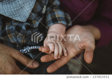 Baby Hand Held by Adult in a Tender Moment Baby Hand Held by Adult in a Tender Moment 137853551