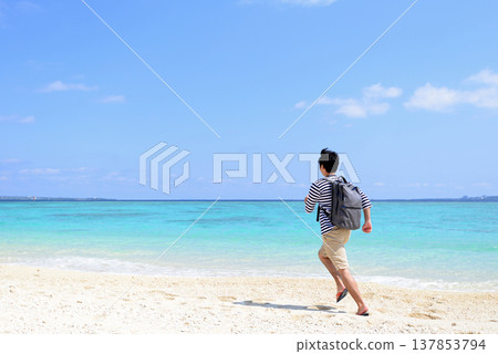 一個年輕人在海灘上奔跑 一個年輕人在海灘上奔跑 137853794