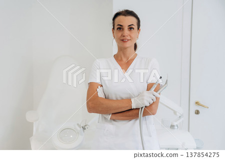 Arms crossed, posing. Podiatrist is in the clinic with equipment 137854275