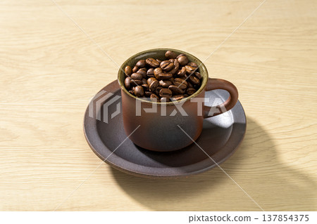 Coffee beans on a wood grain background Coffee beans on a wood grain background 137854375
