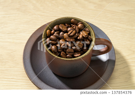 Coffee beans on a wood grain background Coffee beans on a wood grain background 137854376