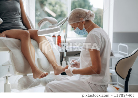 Female podiatrist with woman client in clinic 137854405