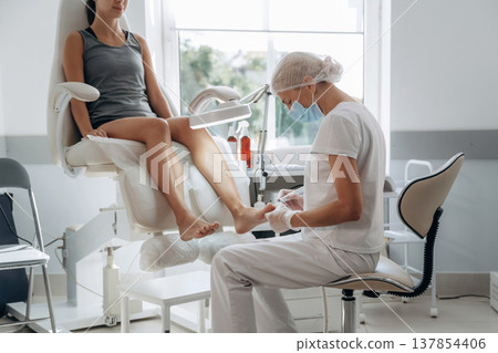Female podiatrist with woman client in clinic Female podiatrist with woman client in clinic 137854406