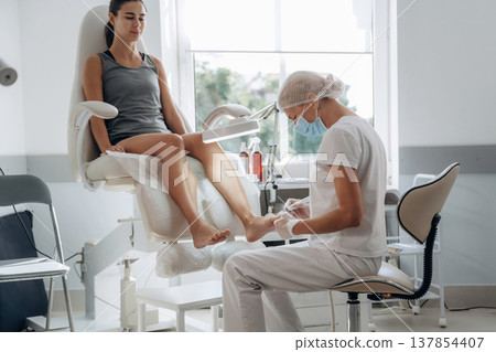 Female podiatrist with woman client in clinic 137854407