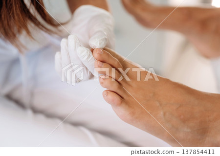 Detailed close up view. Podiatrist with client in clinic 137854411