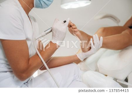 Professional care, work in progress. Podiatrist with client in clinic 137854415