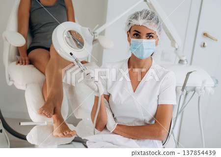 Looking at the camera, sitting. Podiatrist with client in clinic 137854439