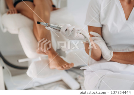 Silver professional peeling equipment. Podiatrist with client in clinic Silver professional peeling equipment. Podiatrist with client in clinic 137854444