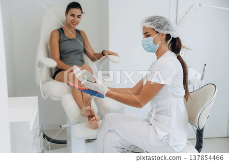 Shape of the feet. Podiatrist with client in clinic 137854466