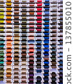 Vertical photo with many thread spools arranged in even rows. Bright image for sewing, tailoring, craft, atelier and textile supply themes. 137855010