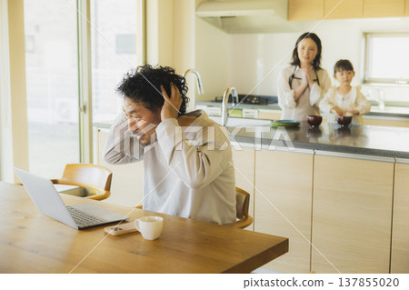 A man working from home in his living room. A man working from home in his living room. 137855020