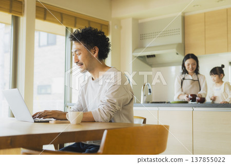 A man working from home in his living room. A man working from home in his living room. 137855022