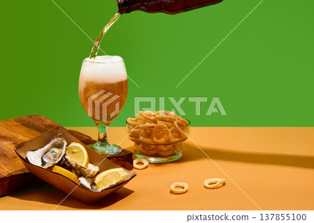 Beer with fresh oysters and lemon squeeze captured in motion on clean background with copy space. Beer with fresh oysters and lemon squeeze captured in motion on clean background with copy space. 137855100