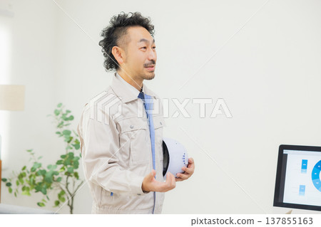 工程師們在辦公室一邊開會一邊查看文件。 工程師們在辦公室一邊開會一邊查看文件。 137855163