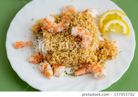 healthy bulgur with shrimp and lemon garnish 137855782