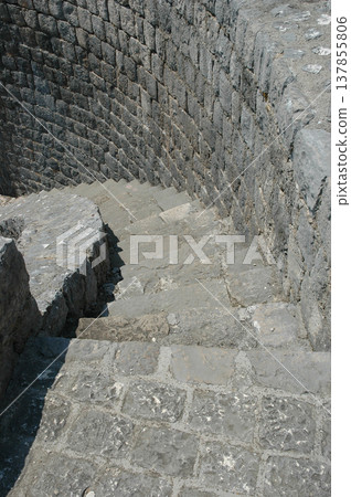 Ancient spiral stone staircase in a fortress Ancient spiral stone staircase in a fortress 137855806