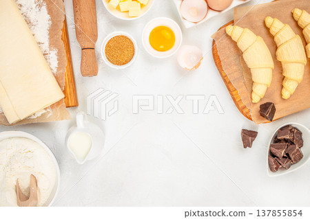 Raw Croissants with Baking Ingredients and Chocolate on White Background Raw Croissants with Baking Ingredients and Chocolate on White Background 137855854