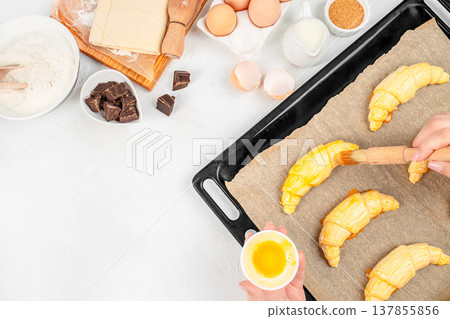 Raw Croissants on Baking Tray with Egg Wash and Ingredients Raw Croissants on Baking Tray with Egg Wash and Ingredients 137855856