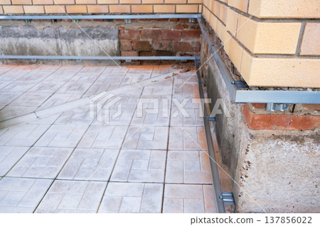 Repair of the foundation and walls of the house with the installation of metal sheets on the frame for finishing the basement. 137856022