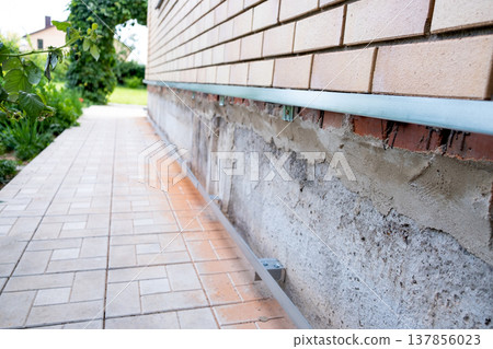 Repair of the foundation and walls of the house with the installation of metal sheets on the frame for finishing the basement. Repair of the foundation and walls of the house with the installation of metal sheets on the frame for finishing the basement. 137856023